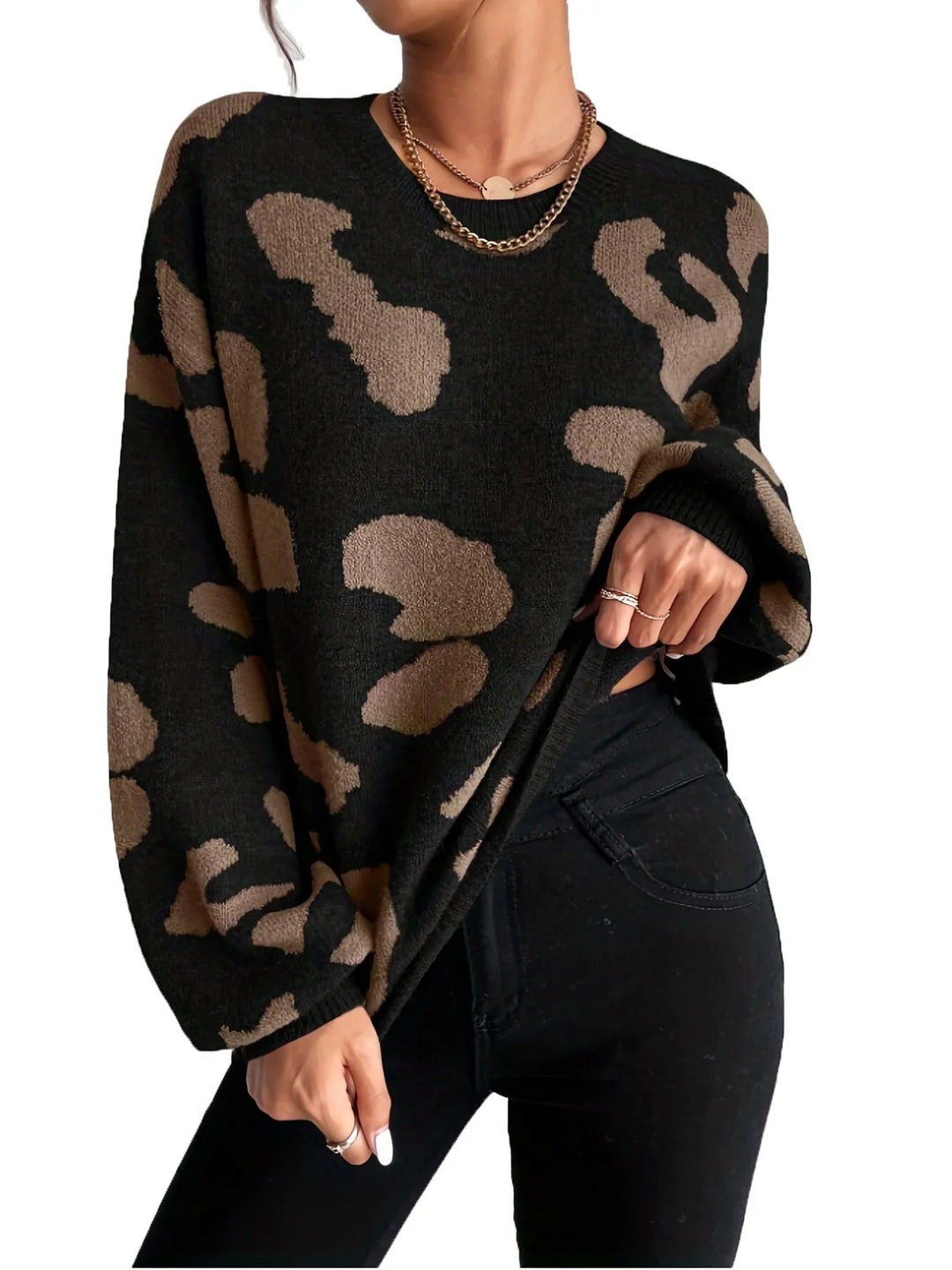 Woman wearing black and brown leopard print sweater and black jeans with gold necklace