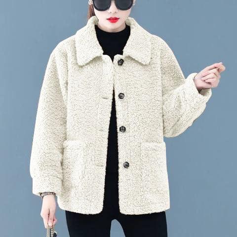 Woman wearing cream sherpa fleece jacket with black buttons, black turtleneck, and sunglasses
