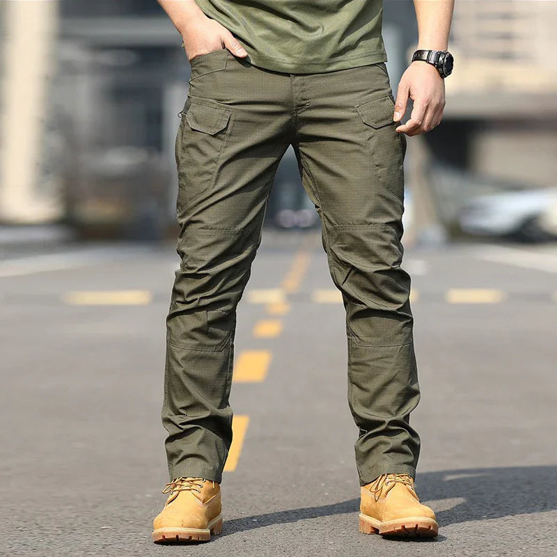 Man wearing olive green cargo pants and tan work boots on urban street background