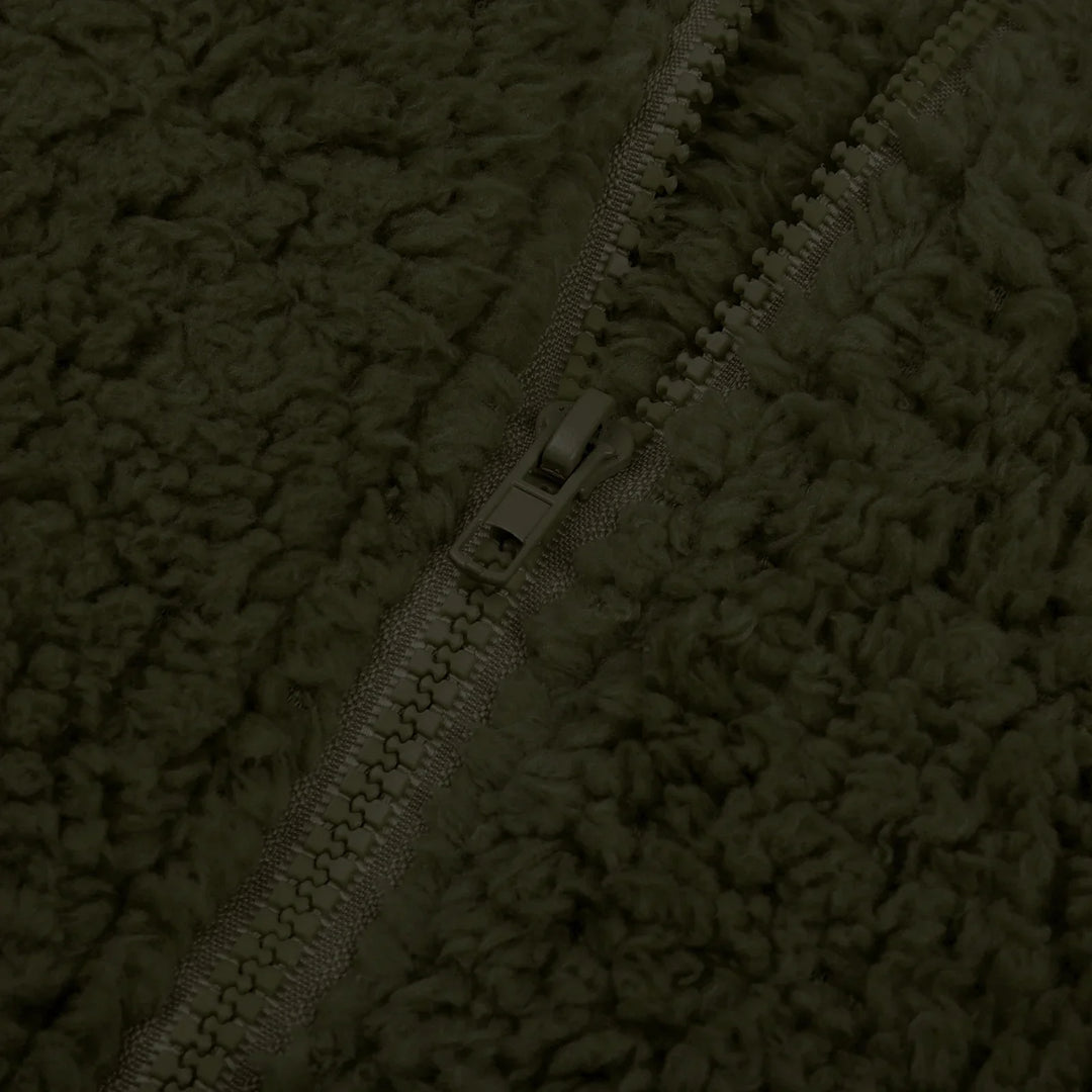 Close-up of dark olive green fleece fabric with a front zipper detail
