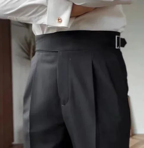 Close-up of person wearing black tailored trousers with side belt and white shirt with cufflink