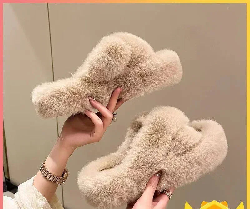 Pair of cozy beige fluffy slippers held by hands, perfect for indoor comfort and warmth