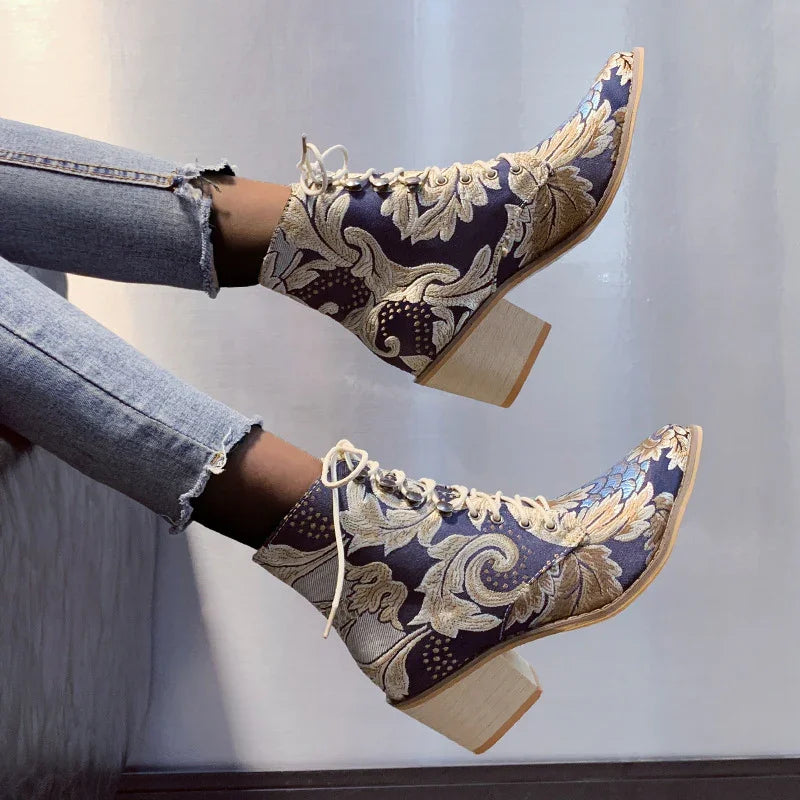 Lace-up embroidered ankle boots with floral pattern and wooden block heels worn with frayed hem jeans