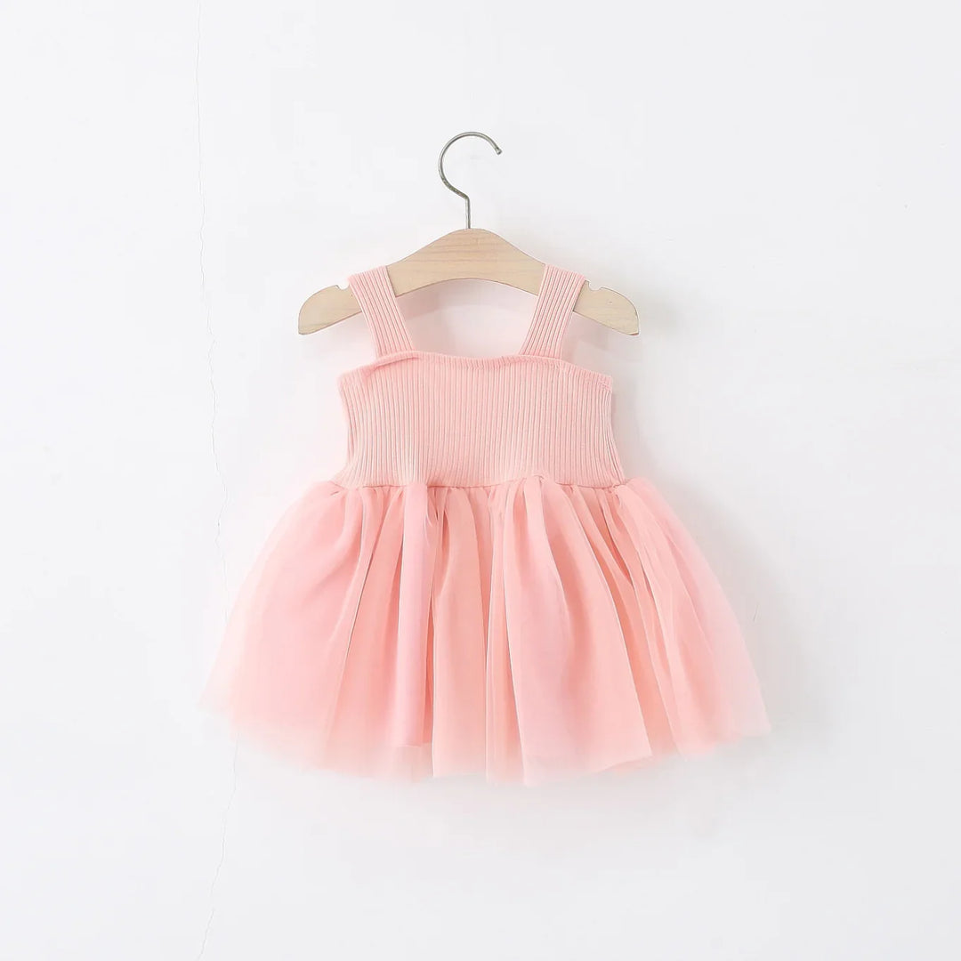 Pink toddler dress with ribbed bodice and tulle skirt hanging on wooden hanger