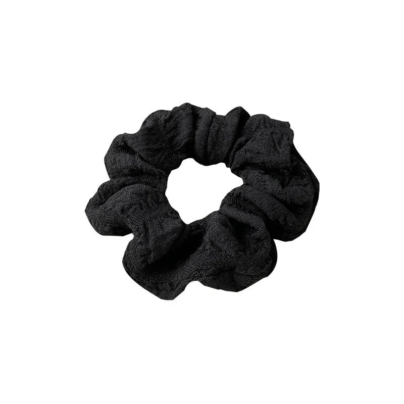 Black textured fabric hair scrunchie isolated on white background