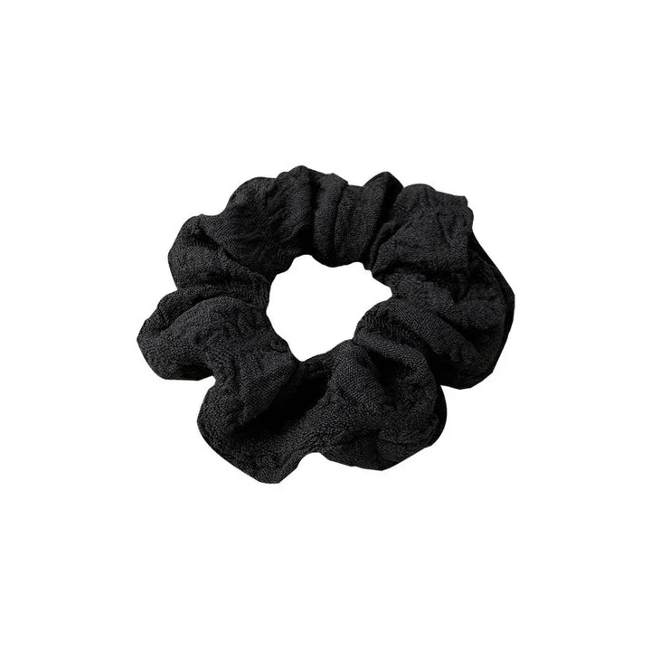 Black textured fabric hair scrunchie isolated on white background