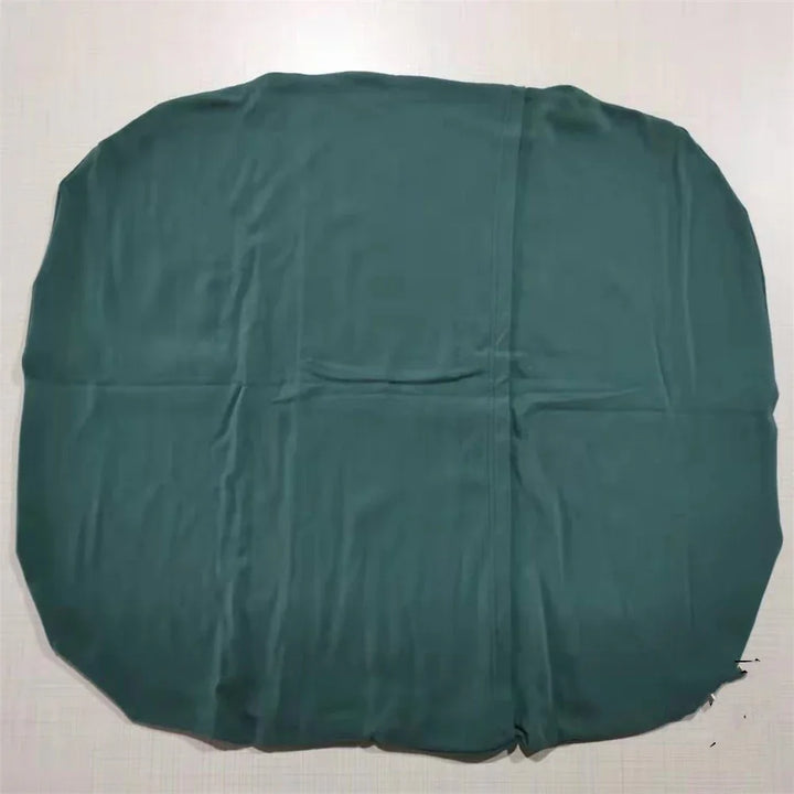 Dark green rounded fabric cover laid flat on white surface with visible creases