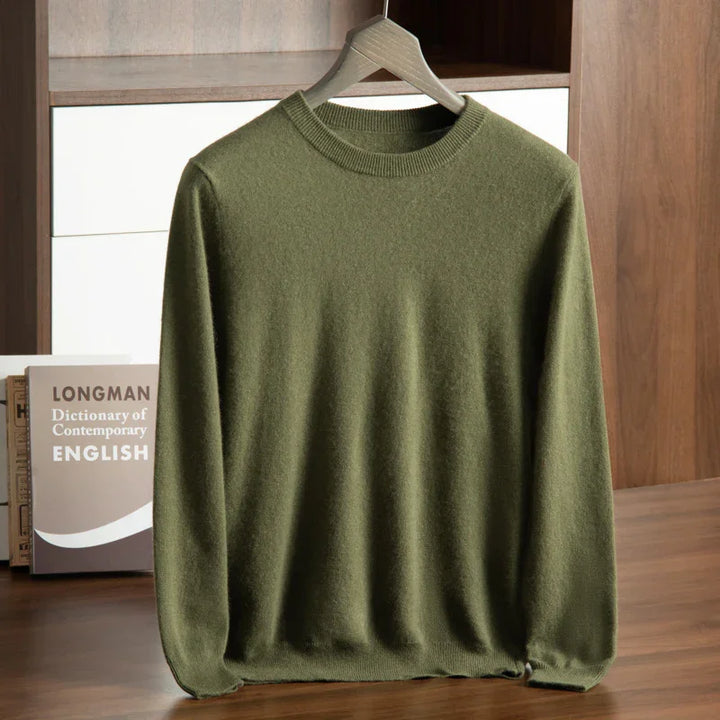Olive green crewneck sweater hanging on wooden hanger with Longman English dictionary in background