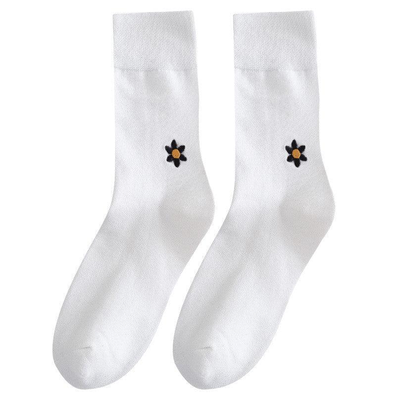 Pair of white crew socks with black and yellow flower embroidery on each side