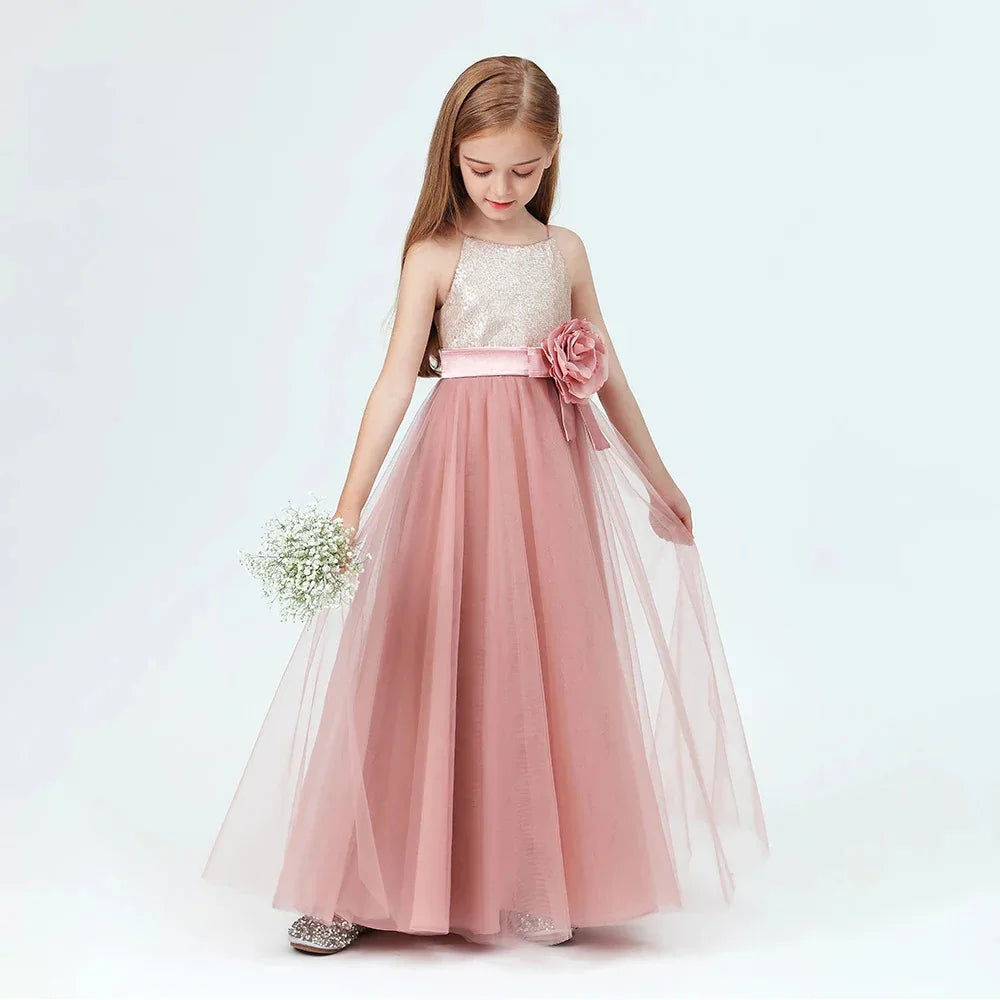 Young girl in a pink tulle flower girl dress holding white baby's breath bouquet