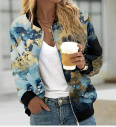 Woman wearing blue and gold tie-dye bomber jacket over white shirt, holding a coffee cup