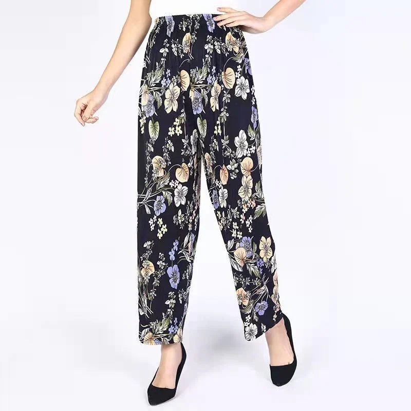 Woman wearing black floral print wide-leg pants with elastic waistband and black heels