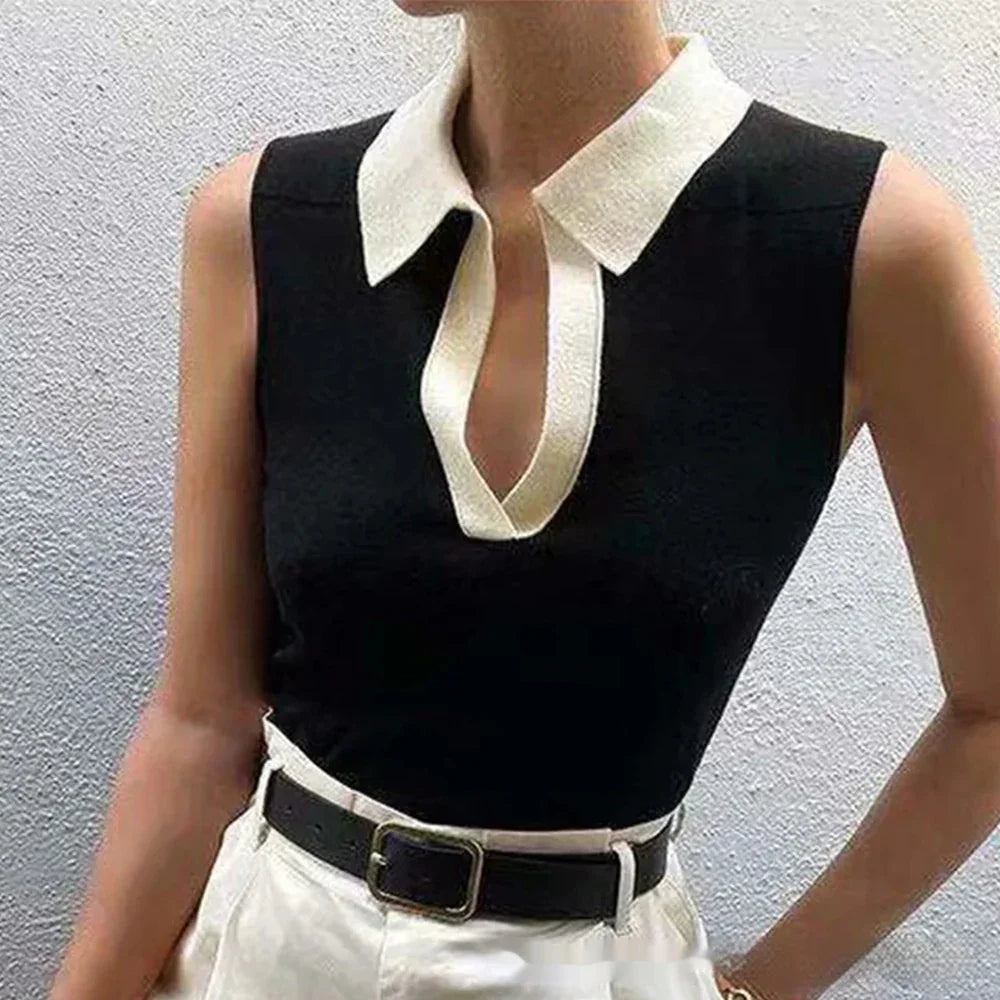 Sleeveless black top with white collar and V-neck, paired with white pants and black belt