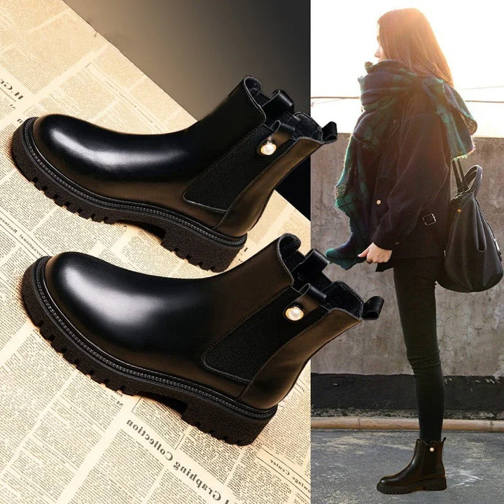 Black leather Chelsea boots with pearl side detail on newspaper background and worn with casual outfit