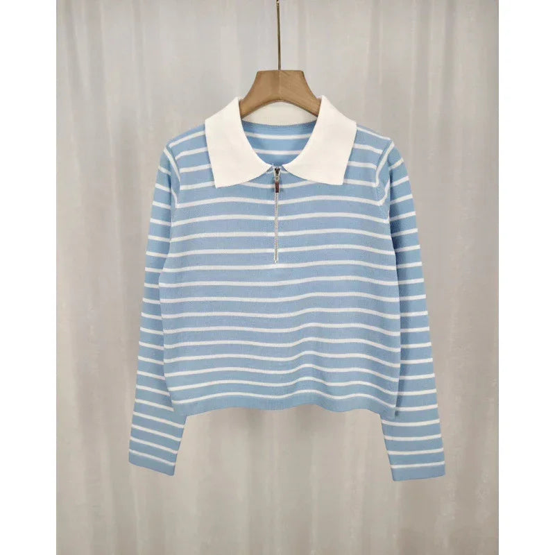 Blue and white striped long-sleeve knit sweater with white collar and zipper on wooden hanger