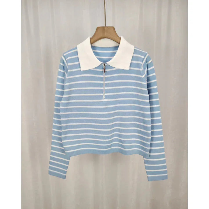 Blue and white striped long-sleeve knit sweater with white collar and zipper on wooden hanger