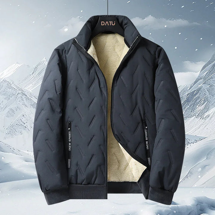Black insulated winter jacket with fleece lining and zippered pockets against snowy mountain background