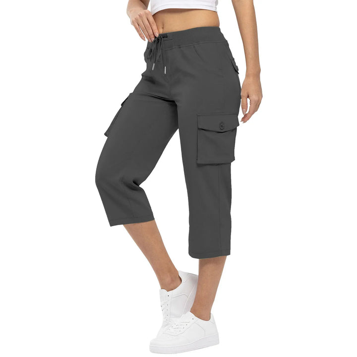 Woman wearing dark gray cargo capri pants with drawstring waist and white sneakers