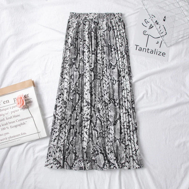 Black and white pleated snake print midi skirt on white fabric with paper props
