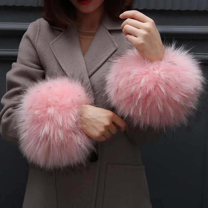 Woman wearing gray coat with fluffy pink fur cuffs on sleeves in stylish winter outfit