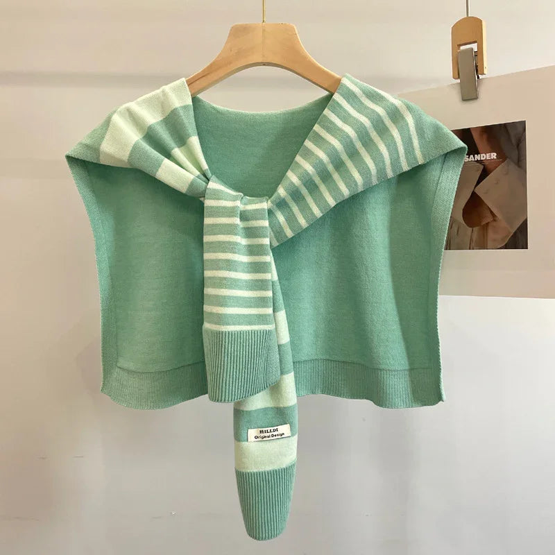 Mint green knit sweater draped over hanger with striped sleeves and casual modern design