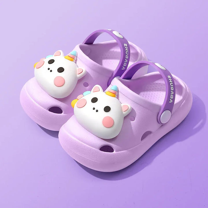 Purple kids clogs with cute unicorn face decoration and adjustable heel strap on purple background