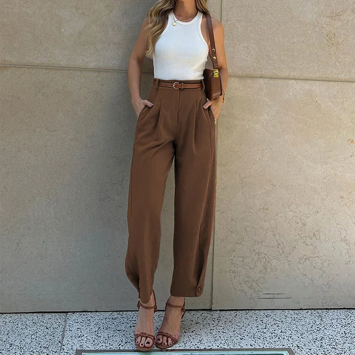 Woman wearing white sleeveless top and high-waist brown wide-leg pants with ankle straps