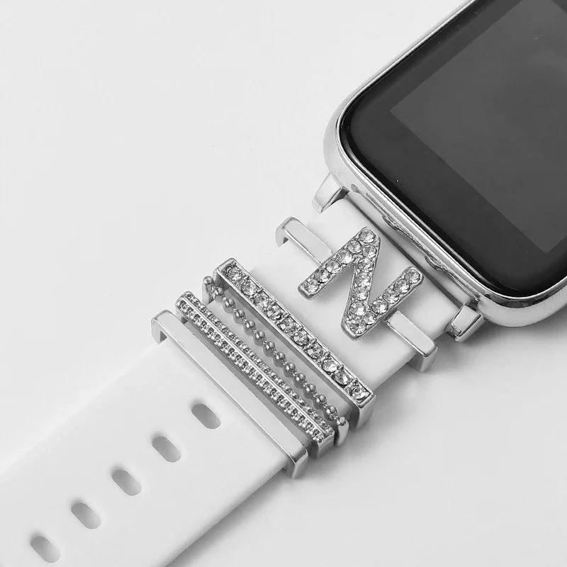 Smartwatch with white band decorated with silver rhinestone charms including a letter N