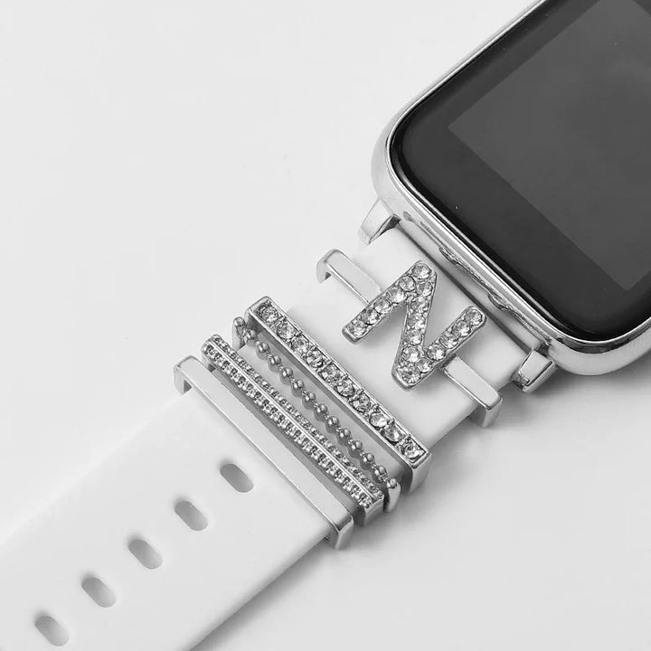 Smartwatch with white band decorated with silver rhinestone charms including a letter N