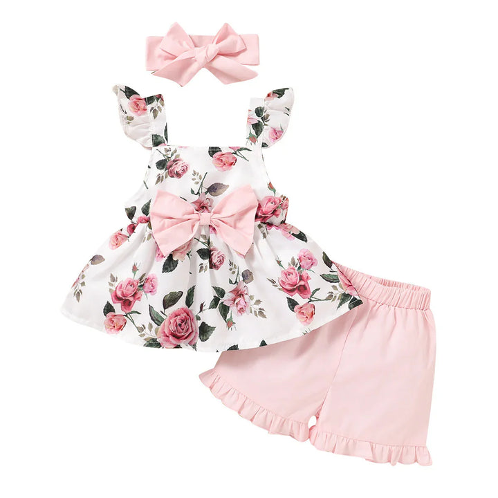 Baby girl floral summer outfit with pink bow headband, rose print top, and pink ruffled shorts