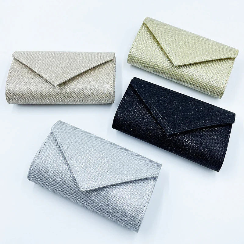 Set of four glittery envelope clutch bags in gold, silver, champagne, and black on white background