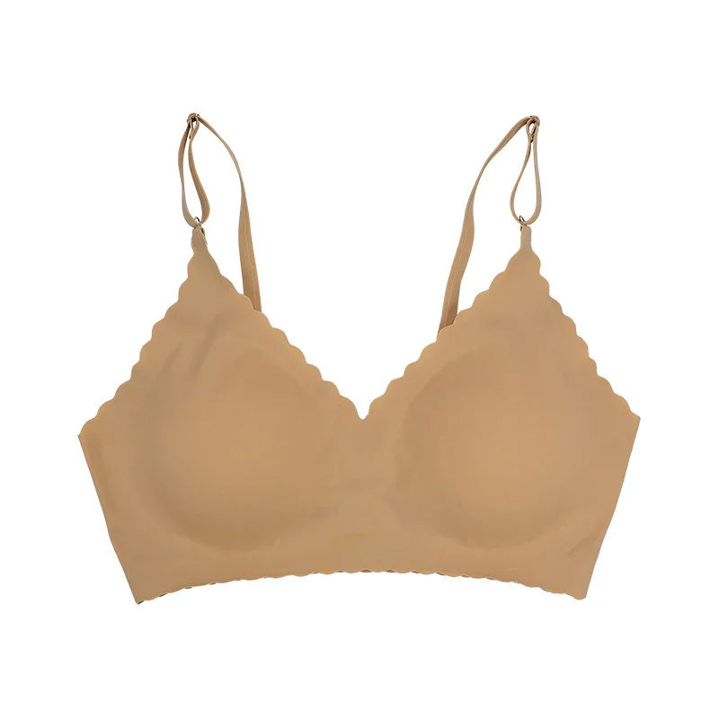 Nude beige seamless wireless bra with scalloped edges and adjustable straps on white background