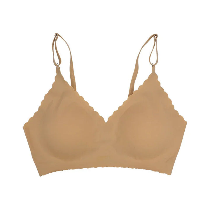 Nude beige seamless wireless bra with scalloped edges and adjustable straps on white background