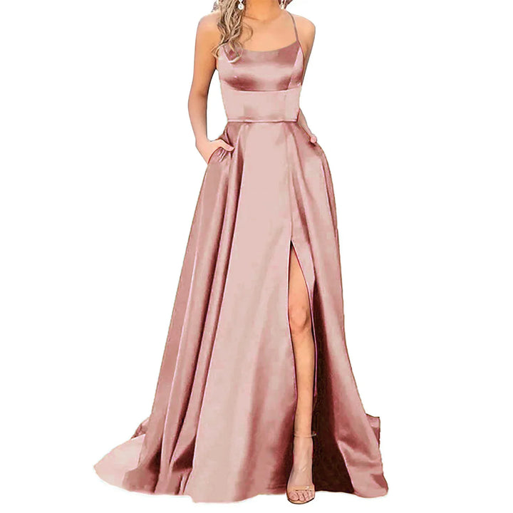 Elegant pink satin evening gown with spaghetti straps, side slit, and pockets, worn by woman