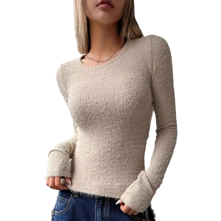 woman wearing beige textured long-sleeve knit sweater with raw edges and blue jeans