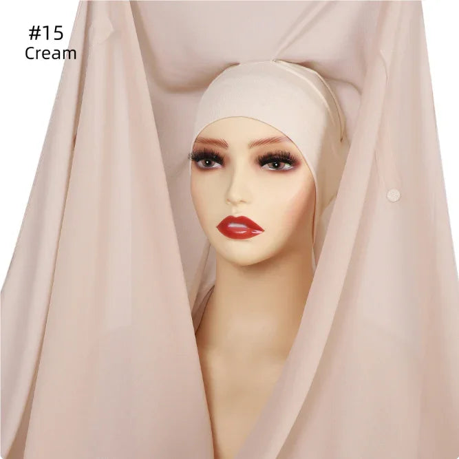 Mannequin head wearing cream hijab inner cap with red lipstick and long eyelashes
