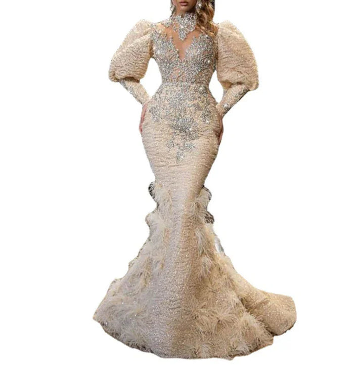 Elegant beige mermaid gown with puff sleeves, intricate silver embroidery, and feathered train