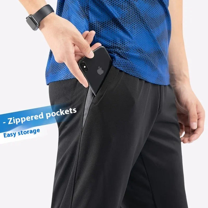 Person wearing black zippered pocket pants with smartphone being stored, showcasing easy storage feature