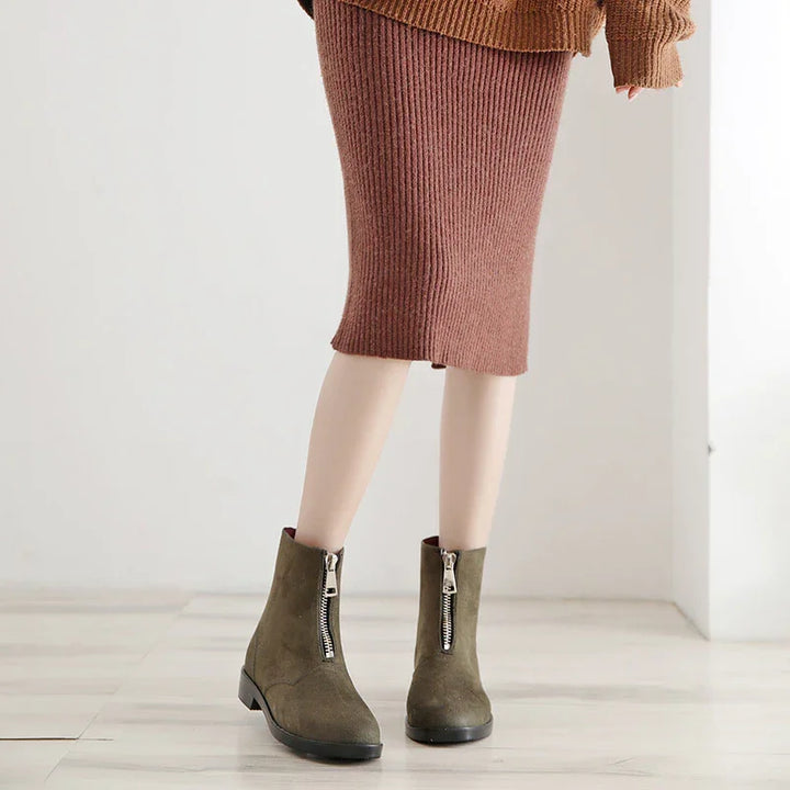 Woman wearing brown ribbed knit midi skirt and olive green suede ankle boots with front zippers