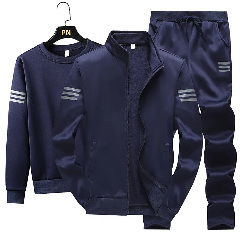 Navy blue men's sportswear set with zip-up jacket, sweatshirt, and drawstring pants featuring silver stripe accents