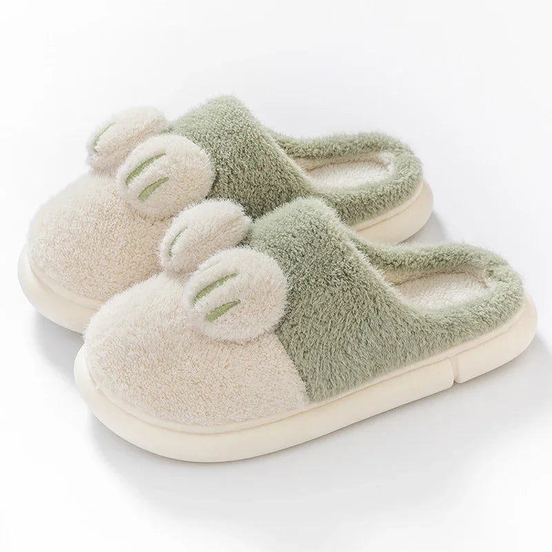 Cozy green and beige fuzzy slippers with cute bear ear accents on a white background