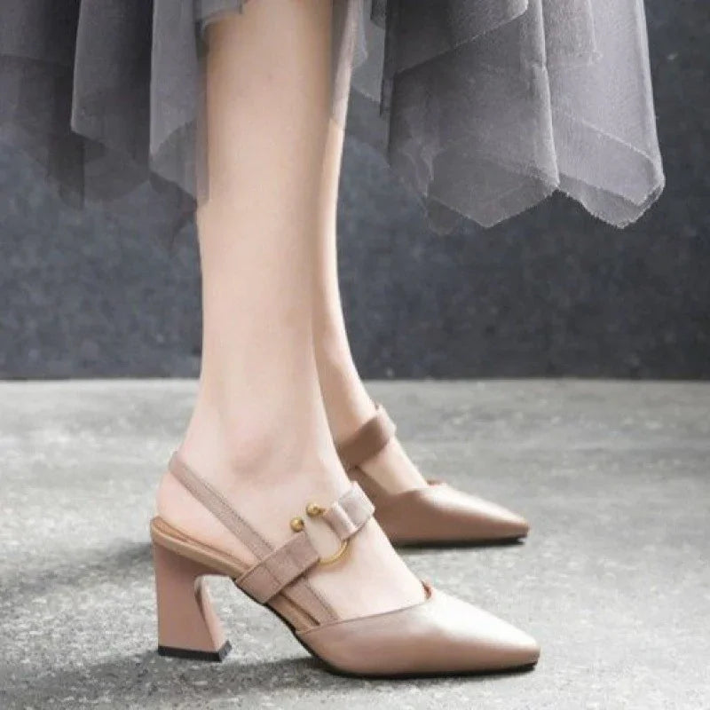 Beige pointed toe block heel slingback shoes with buckle detail on model's feet
