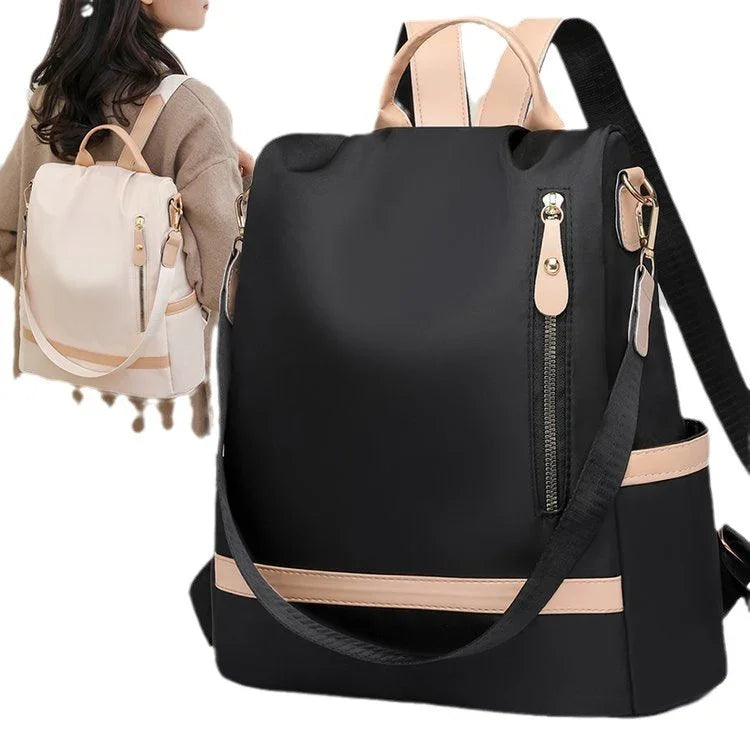 Black and beige women's backpack with zippered pocket and adjustable straps, shown worn by model