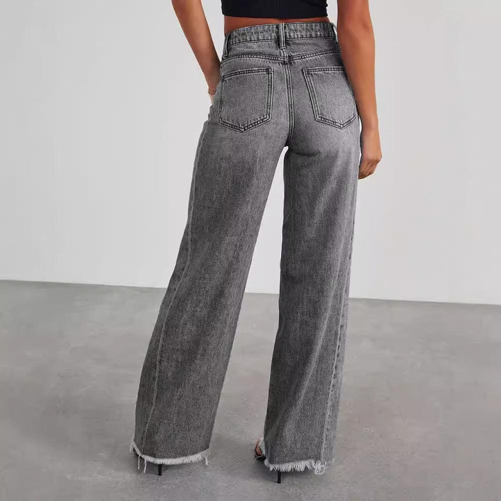 Back view of woman wearing high-waisted gray washed wide-leg jeans with raw hem