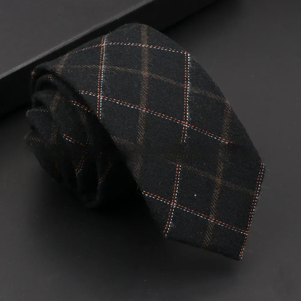 Rolled black wool necktie with orange and white plaid pattern on black background