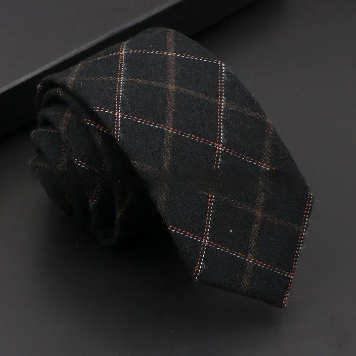 Rolled black wool necktie with orange and white plaid pattern on black background
