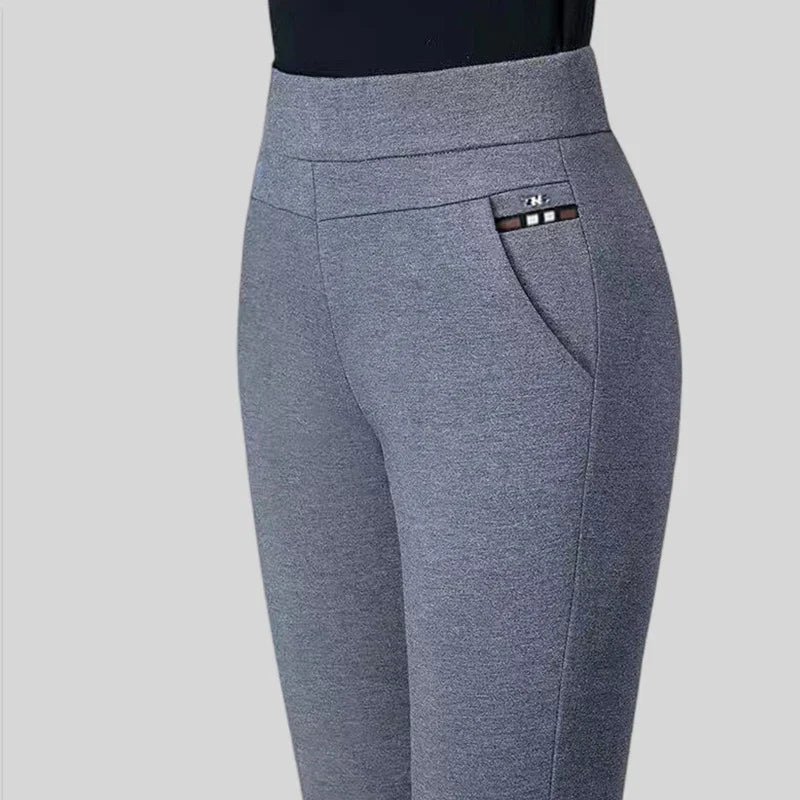 Close-up of stylish grey women's pants with side pocket and black top against plain background
