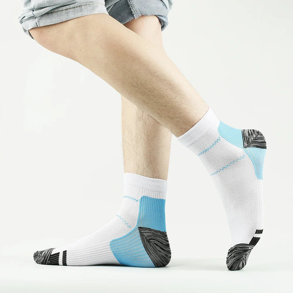 Person wearing white, blue, and black ankle athletic socks with rolled-up gray pants