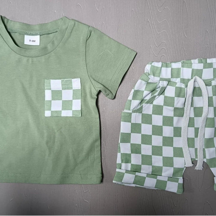 Green baby outfit with checkered pocket and matching checkered shorts, size 0-6M