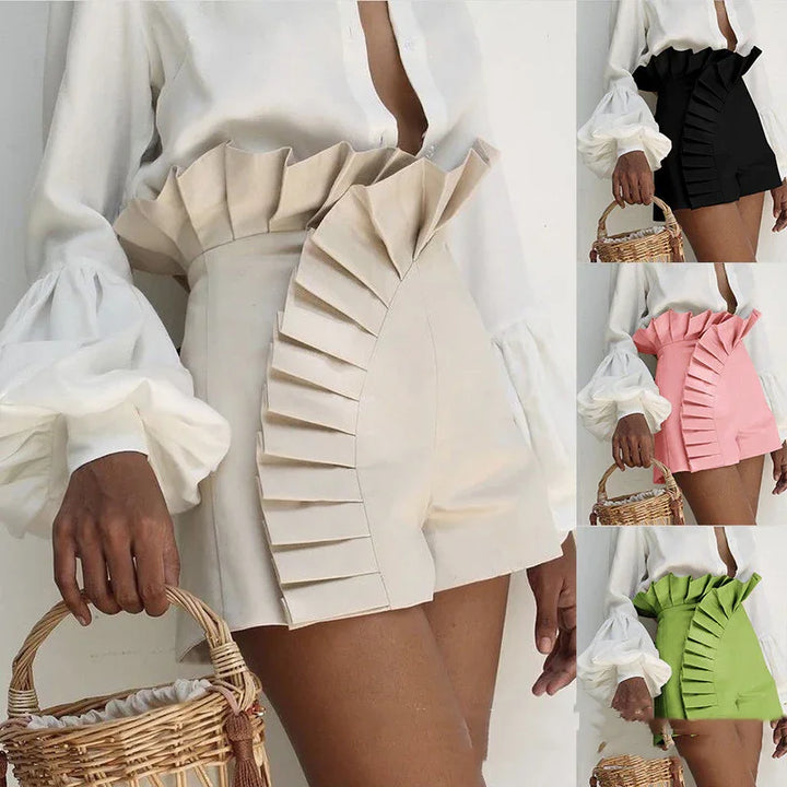 Women wearing high-waisted shorts with large pleated ruffle detail in beige, black, pink, and green colors, styled with white puff-sleeve tops and holding wicker baskets